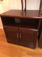 Front view showing open shelf and cabinet doors with brass handles