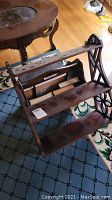 Side angle of wood shelf and mahogany magazine rack with visible scratches and missing knob on magazine rack
