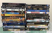 Two stacks of assorted DVDs showing titles like Don Cherry 20, Men in Black, Saving Private Ryan, Star Wars, Ocean's Eleven, and more.