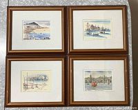 Four framed lithographs arranged in two rows of two on a patterned background