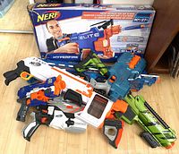 Group photo showing all seven Nerf toy blasters with one in box and six loose, highlighting model details and colors