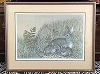 Framed lithograph print showing three rabbits in grass and fern, nicely matted and framed.