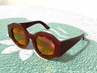 Three angles of dark red House Of Holland Crowning Glory sunglasses with octagonal glittery front frame and reflective red-orange lenses, showing condition and detailing.