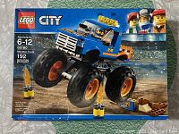 Front of Lego City Monster Truck 60180 box showing the assembled monster truck jumping over flame obstacles inside a stadium. Box indicates 192 pieces, ages 6-12.