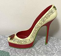 Side and angled views of polystone high heel wine bottle holder with holly and scroll decoration