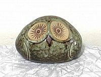 Front view of vintage ceramic owl figurine showing detailed eyes and mottled green glaze with shiny finish.