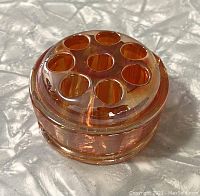 Top angled view showing the shape, holes, and marigold iridescent finish.