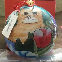 Close-up image of Neiman Marcus vintage Christmas ornament showing inside-painted cat and floral design, with tag attached