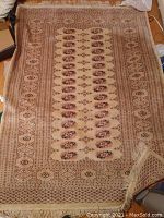 Full view of the rectangular carpet showing the overall pattern including central medallions and geometric border design.