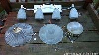 Photo of all three light fixtures laid out showing the bath fixture, two ceiling lights, and mounting accessories.