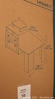 Photo of the product box with printed assembly diagram and dimensions showing desk size and drawer layout.