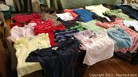 Various kids girls tops in different colors and styles laid out on a table