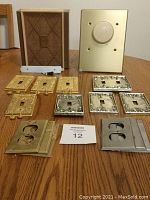 Overview of all items including doorbell, dimmer switch, gold and silver cover plates on wooden surface