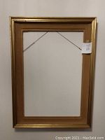 Full view of the wooden gold picture frame with felt inner layer, showing overall condition and size.