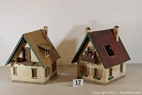 Front view showing both weathered European style buildings side by side. One has brown roof, the other red roof with Sesame Place figures on balcony.