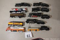 Top down view of all engines and tenders on a white surface including Chessie System diesel, Pennsylvania steam, and others