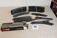 Multiple Bachmann E-Z Track straight and curved track pieces along with a boxed Kato Unitrack straight track section