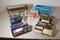 Seven HO scale model train kits displayed in their original open boxes, including a large Walthers enclosed auto carrier and other freight car kits.