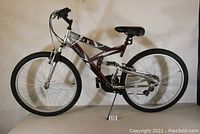 Full side view of the men's hybrid mountain bike, showing full frame, wheels, seat, and kickstand.