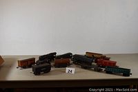 Lot showing all train cars and engines arranged in one group on a beige surface against a white background.