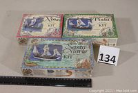Three sealed wooden tall ship kits for Nina, Pinta, and Santa Maria ships with ruler for scale.