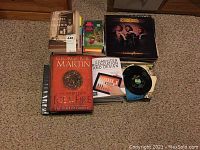 Overview of all books and records laid on carpeted floor including music albums and hardcover books