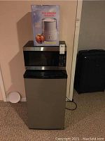 Photo showing GE microwave on top of Frigidaire mini fridge with boxed Deni ice cream maker on top of microwave.