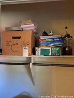 Box with 100 file folders, box with 50 hanging file folders, GE green lantern, assorted office supplies in plastic container