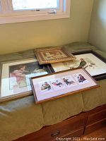 Four framed wall art pieces placed on a green surface, showing all the artworks and their frames.