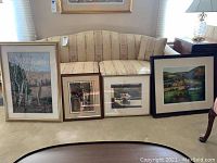 Four framed and matted art pieces displayed on the floor against a sofa, showing overall size and framing styles