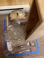 Vintage Farberware electric frying pan and clear glass punch bowl with ladles inside and rustic wooden box at the side.