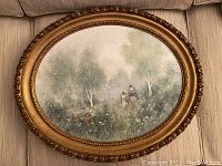 Oval framed oil painting showing a misty Impressionist-style landscape with two figures among trees and wildflowers.