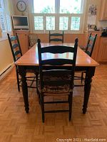 Full view of dining table set with four chairs surrounding table.