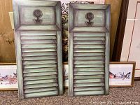 Two vertical shutter-style prints with a weathered green finish and keyhole motif.