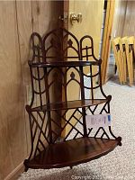 Side angled photo of the wooden 3-shelf wall unit showing the overall design and condition.