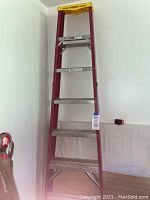 Full frontal view of the Werner fiberglass step ladder approximately 7 ft tall against a wall indoors.