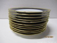Stack of 11 cobalt blue and gold luncheon plates showing side profile and thickness.