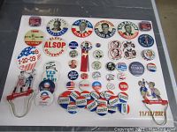 Full view of various political campaign pins covering multiple decades including candidates like Nixon, Obama, Kennedy, and others for sale in assortment.
