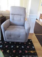 Front view of the recliner chair showing stonewash dove fabric and padded armrests and backrest.