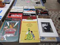 Photo showing multiple songbooks arranged on a table featuring Broadway shows and musical artists, titles clearly visible.