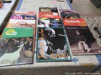 Photo of a collection of assorted songbooks from various famous artists laid out on a table showing covers and titles.