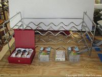 Photo of assembled metal wine rack with decorative items in front including gemstone wine stoppers and stacks of playing cards.