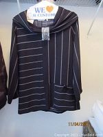 Black zip-up cardigan with gray horizontal stripes and draped collar hanging on hanger with Soft Surroundings label visible