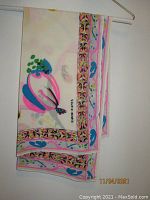 David Hayes multi-color printed wrap draped on hanger showing border with pink, black, yellow, blue and green accents