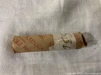 Photo of a single brown kraft paper roll labeled 1953 D likely containing Lincoln Wheat pennies.