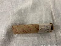 Photo of a tightly wrapped paper roll containing 1957 D wheat pennies with hand labeling and original penny wrapper.