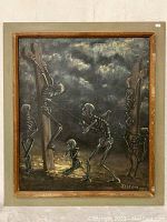 Photo of entire framed oil painting showing skeletons at crucifixion scene, signed and dated.