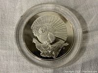 Close-up of the proof coin showing the detailed Ruffed Grouse design encased in clear plastic.