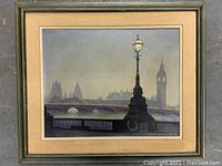 Framed oil painting showing a foggy cityscape with a big ornate street lamp in front and a large stone bridge with arches, background includes iconic clock tower resembling Big Ben.