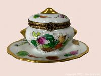 Front angle close-up of the Limoges hand painted tureen pill box showing detailed vegetable motifs and gold trim.